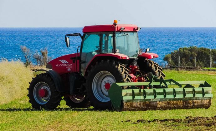 tractor in a coastal field with a roller attached