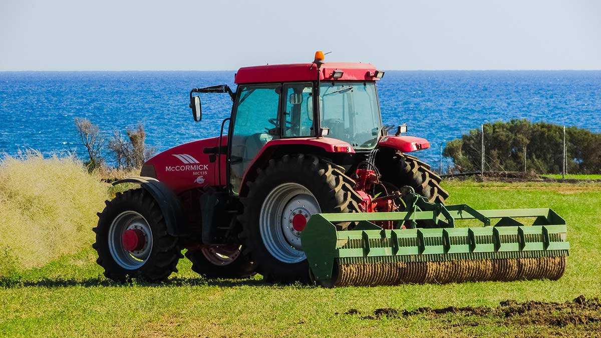 tractor in a coastal field with a roller attached