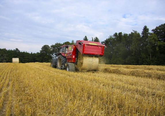 Round baler working in a field